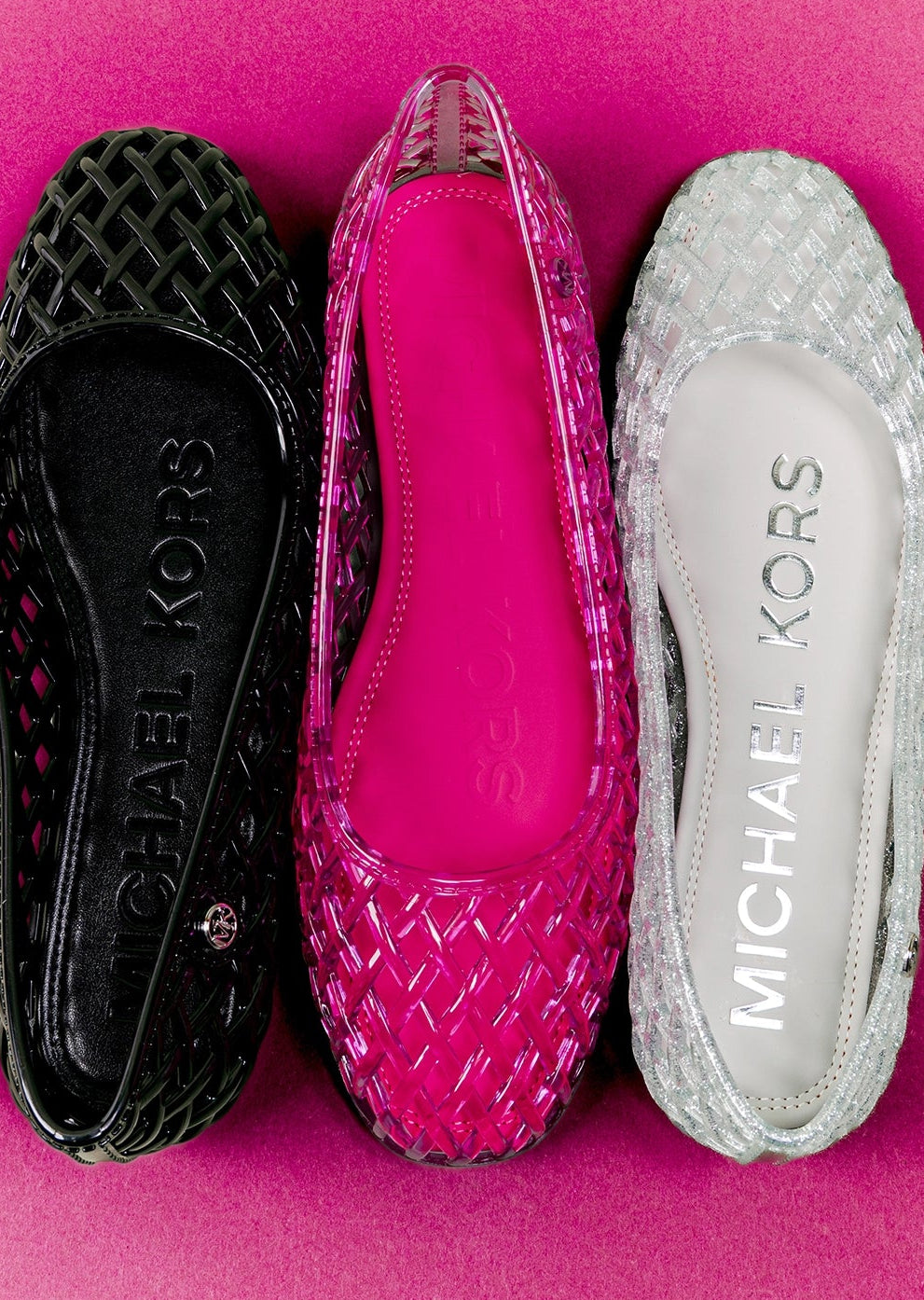 Three Michael Kors shoes in black, pink, and silver on a pink background